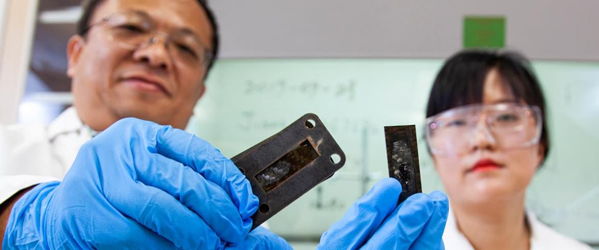 Industrial and Manufacturing engineering research faculty members professors Ayou Hoa, Ph.D and Zhiyong (Richard) Liang, Ph.D. holding pieces of thin heat shields for superfast aircraft.