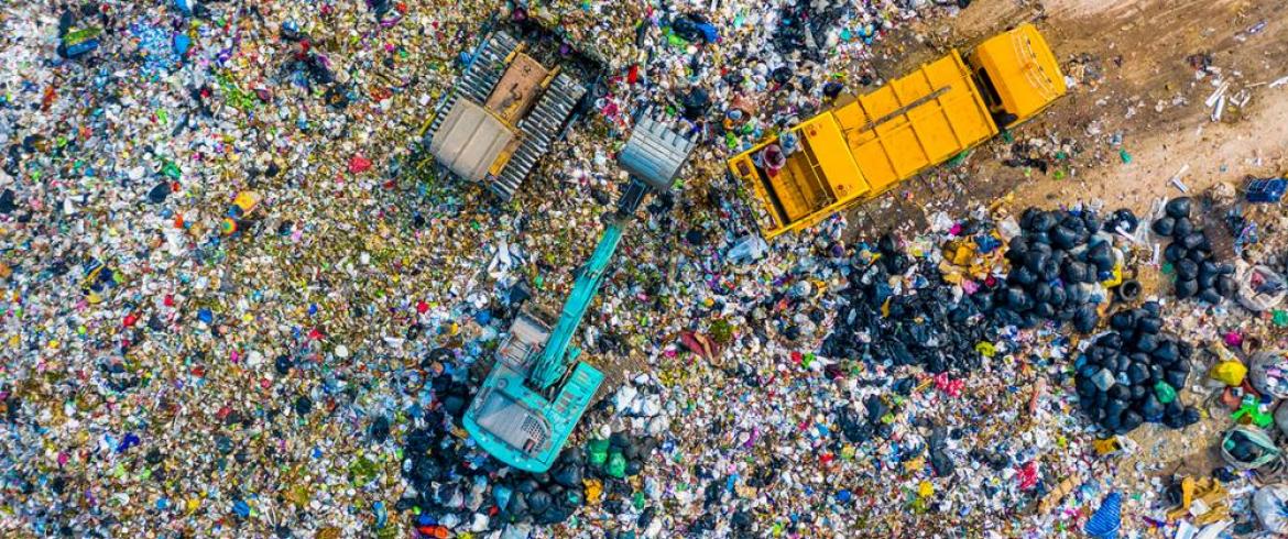 Aerial view of landfill with dump trucks and crane